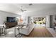 Cozy living room with wood flooring, ceiling fan, and sliding doors to the backyard at 2919 Monument Way, The Villages, FL 32163