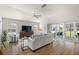 Bright living room featuring modern decor, wood floors, a ceiling fan, and sliding glass doors at 2919 Monument Way, The Villages, FL 32163