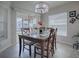 Bright dining room with chandelier, natural light, and tile flooring near sliding glass doors to the screened lanai at 2922 Rain Lily Loop, The Villages, FL 32163