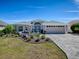 Beautiful single-story home with well-manicured lawn, paver driveway and outdoor fire pit feature at 2922 Rain Lily Loop, The Villages, FL 32163