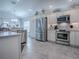 Modern kitchen with stainless steel appliances, white cabinetry, and tile floors at 2922 Rain Lily Loop, The Villages, FL 32163