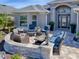 Outdoor seating area features stone accents, an arched entryway, and pavers at 2922 Rain Lily Loop, The Villages, FL 32163