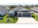 Aerial view of the house showcasing its location, landscaping, and three-car garage at 3334 Pierluissi Path, The Villages, FL 32163