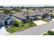 Aerial view of a well-maintained home with lush landscaping, a manicured lawn, and a paved driveway at 3334 Pierluissi Path, The Villages, FL 32163