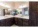 Bathroom featuring a double sink vanity with quartz countertops and dark wood cabinets at 3334 Pierluissi Path, The Villages, FL 32163