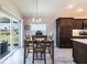 Bright dining area with wood table set, modern lighting, and sliding glass doors to the outside at 3334 Pierluissi Path, The Villages, FL 32163