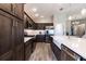 Charming kitchen with dark wood cabinets, stainless steel appliances, and a white farmhouse sink at 3334 Pierluissi Path, The Villages, FL 32163