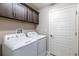 Laundry room with washer, dryer, cabinets and a door to another part of the home at 3334 Pierluissi Path, The Villages, FL 32163