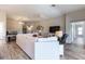 Bright living room featuring hardwood floors, a ceiling fan, and views into other areas of the home at 3334 Pierluissi Path, The Villages, FL 32163