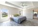 Bright main bedroom with tray ceiling, ceiling fan, and large windows providing ample natural light at 3334 Pierluissi Path, The Villages, FL 32163