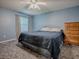 Comfortable bedroom with blue walls, ceiling fan, and gray patterned carpeting at 337 Olanta Dr, The Villages, FL 32162