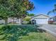 Charming home featuring well-maintained landscaping, a two-car garage, and a tidy front yard at 337 Olanta Dr, The Villages, FL 32162