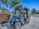 Golf cart with blue body and canopy parked on the concrete driveway at 337 Olanta Dr, The Villages, FL 32162