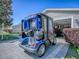 Rear view of blue golf cart parked in front of open garage on driveway at 337 Olanta Dr, The Villages, FL 32162