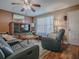 Inviting living room featuring wood floors, comfortable seating and natural light from the window at 337 Olanta Dr, The Villages, FL 32162