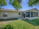 Backyard view showing a screen lanai, small patio, and well-kept lawn area at 337 Olanta Dr, The Villages, FL 32162