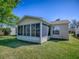 Image showcasing the rear of the property, featuring a screened-in lanai and tidy lawn at 337 Olanta Dr, The Villages, FL 32162