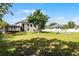 Expansive backyard featuring lush lawn space, screened porch, mature tree, and a basketball court at 342 Lake Amberleigh Dr, Winter Garden, FL 34787