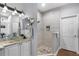 Modern bathroom featuring dual vanities, a walk-in shower, and decorative mirrors at 342 Lake Amberleigh Dr, Winter Garden, FL 34787