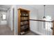 Upstairs hallway featuring a built-in bookshelf and access to bedrooms at 342 Lake Amberleigh Dr, Winter Garden, FL 34787