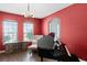 Living room with red walls, a grand piano, and a seating area near a window for natural light at 342 Lake Amberleigh Dr, Winter Garden, FL 34787