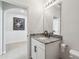 Bathroom featuring a granite vanity, white cabinets, and decorative painting on the wall at 3646 Maidencain St, Clermont, FL 34714