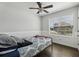 Cozy bedroom with a ceiling fan, decorative trim, and a large window overlooking the yard at 3646 Maidencain St, Clermont, FL 34714