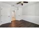 Bedroom features ceiling fan, dark wood-look floors, and paneling at 3646 Maidencain St, Clermont, FL 34714