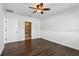 Bedroom with ceiling fan, dark wood-look floors, and ensuite bathroom at 3646 Maidencain St, Clermont, FL 34714