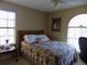 Cozy bedroom featuring a floral-patterned bedspread, natural light, and traditional decor at 36709 Sandy Ln, Grand Island, FL 32735