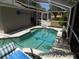 Private screened in pool with lounge chairs and lush landscaping at 36709 Sandy Ln, Grand Island, FL 32735