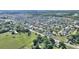 An aerial shot of a neighborhood surrounded by a large field and a line of trees at 410 Majestic Gardens Blvd, Winter Haven, FL 33880