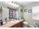 A neat and tidy bathroom with neutral walls, vanity, and shower with patterned curtain at 410 Majestic Gardens Blvd, Winter Haven, FL 33880