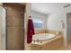 Elegant bathroom featuring a soaking tub, a walk-in shower, and a neutral color palette at 410 Majestic Gardens Blvd, Winter Haven, FL 33880