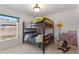 Cozy bedroom with bunk beds, wall decor, and natural light from the window at 410 Majestic Gardens Blvd, Winter Haven, FL 33880