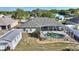 Backyard view of the house with a screened-in pool and well maintained landscaping at 410 Majestic Gardens Blvd, Winter Haven, FL 33880