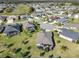 Overhead view of a home and neighborhood featuring a pool, landscaping, and golf course at 4419 Clear Brook Ct, Leesburg, FL 34748