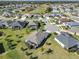 Aerial view of the residential neighborhood with houses and mature trees at 4419 Clear Brook Ct, Leesburg, FL 34748