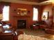 Cozy living room with wood-burning fireplace, mantel mirror and elegant leather furniture at 4419 Clear Brook Ct, Leesburg, FL 34748