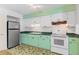 Bright kitchen featuring classic white appliances and retro green base cabinets for a unique style at 450 Liberty Ave # 3, Mount Dora, FL 32757