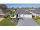 Aerial view of a pristine home featuring a two-car garage, manicured lawn, and landscaping at 4521 Whittingtin Circle, The Villages, FL 32163