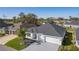 Aerial shot of a well-maintained home featuring a two-car garage, pristine exterior, and lush landscaping at 4521 Whittingtin Circle, The Villages, FL 32163