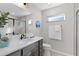 Bright bathroom featuring a gray vanity, white quartz countertops, and a glass-enclosed shower at 4521 Whittingtin Circle, The Villages, FL 32163