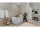 Bright bathroom featuring large free-standing tub, tile floor, and decorative features at 4521 Whittingtin Circle, The Villages, FL 32163