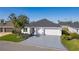 A lovely, single-story home with a two-car garage, pristine exterior, and lush landscaping at 4521 Whittingtin Circle, The Villages, FL 32163