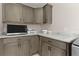 Laundry room with granite countertops, gray cabinets and modern appliances at 4521 Whittingtin Circle, The Villages, FL 32163