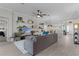 Inviting living room with ceiling fan, decorative shelving, and a comfortable sectional sofa at 4521 Whittingtin Circle, The Villages, FL 32163