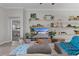 Cozy living room featuring decorative shelving, sectional sofa, and open doorway to the main bedroom at 4521 Whittingtin Circle, The Villages, FL 32163