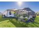 Backyard view of screened-in lanai with pool, black rock garden and tropical landscaping at 4521 Whittingtin Circle, The Villages, FL 32163