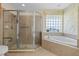 Bathroom showcasing a glass shower and a tub under a glass block window at 4571 Abaco Dr, Tavares, FL 32778